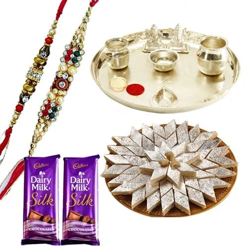 An Exclusive Gift Hamper with Silver Plated Thali, Delicious Kaju Katli and Gift Voucher from Raymond along with 2 free Rakhi,Roli Tika and Chawal